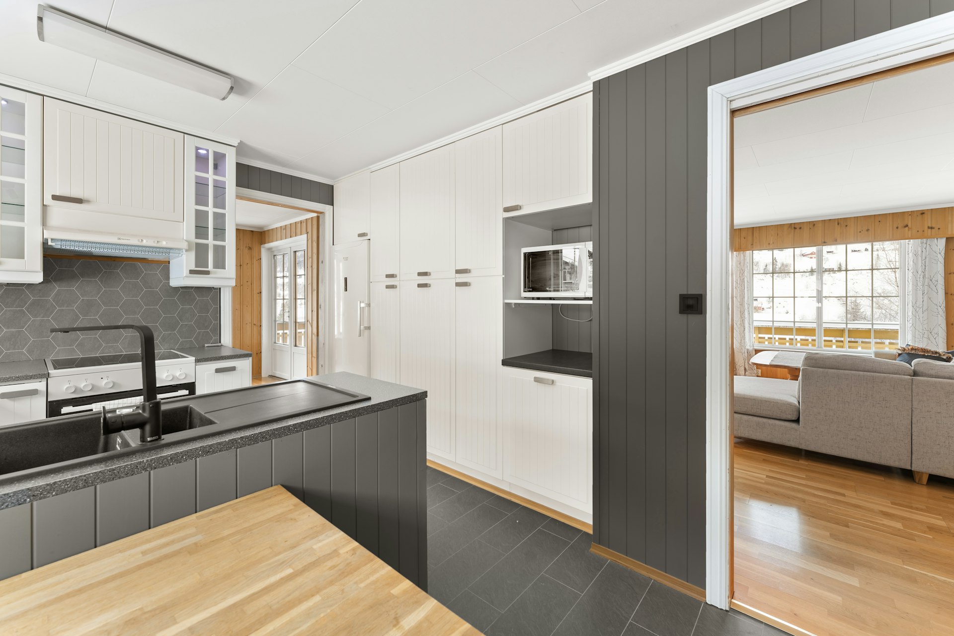 A kitchen with a wooden table and white cabinets